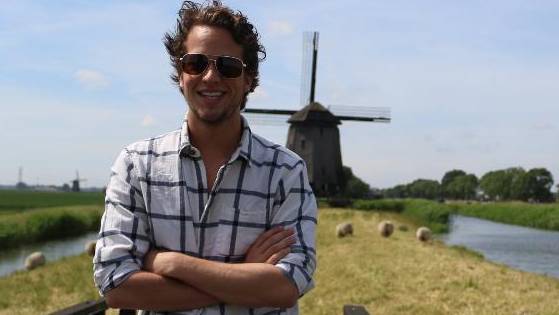 Student posing in front of a windmill in Netherlands